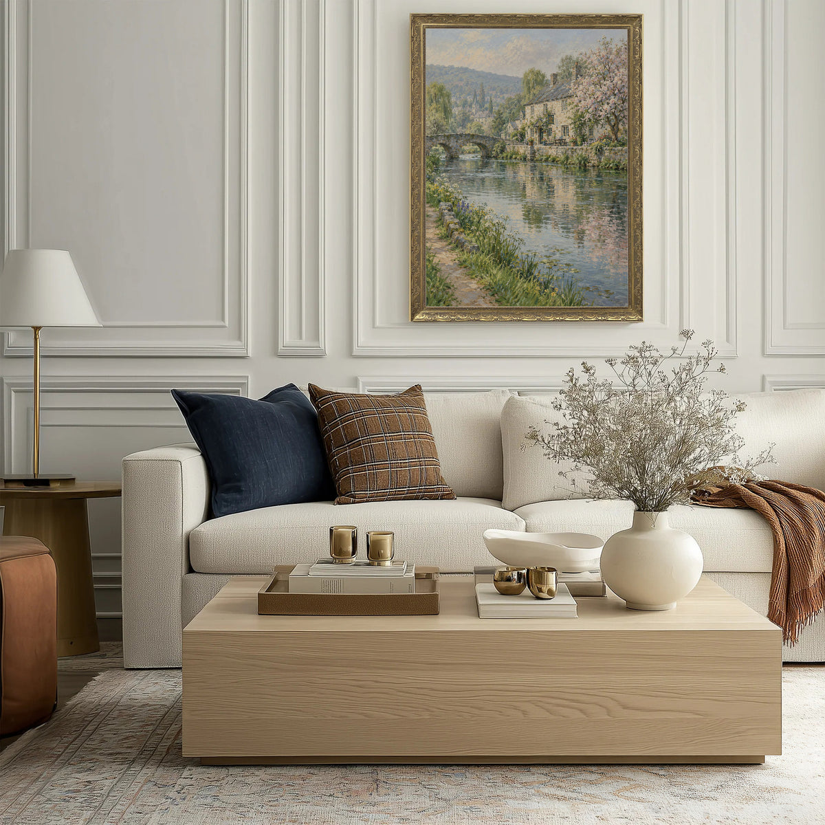 The River Inn Wall Art in a Gold Ornate Frame above a cream sofa in a living room