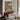 The Shaded Terrace Wall Art in a Gold Ornate Frame above a walnut console in a sitting room