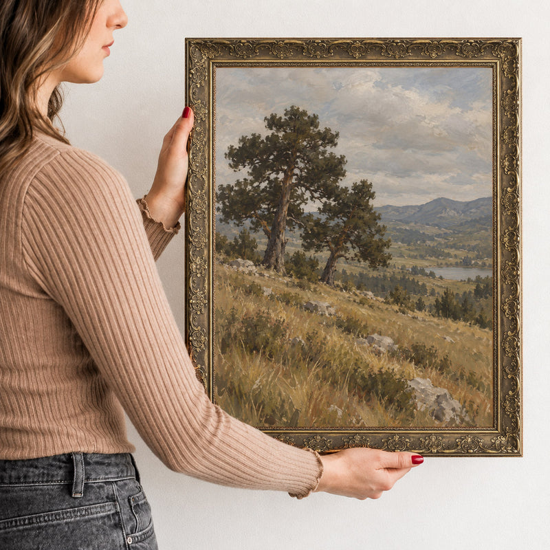 The Twin Pines Wall Art in a Gold Ornate Frame, held to show its size